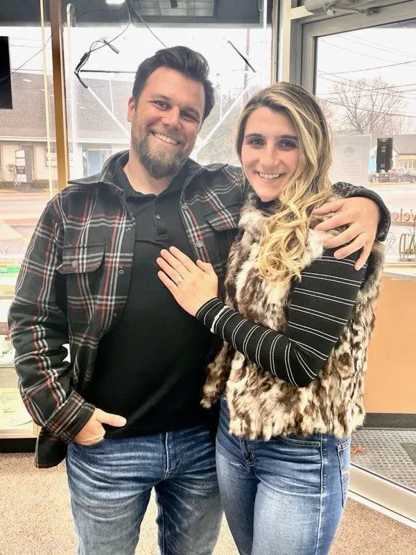 Couple in jewelry store showing off engagement ring