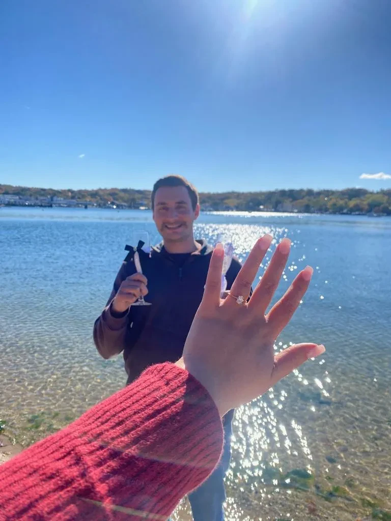 Ring reveal by the lake with champagne