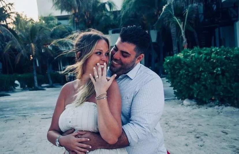Couple celebrating engagement on tropical beach