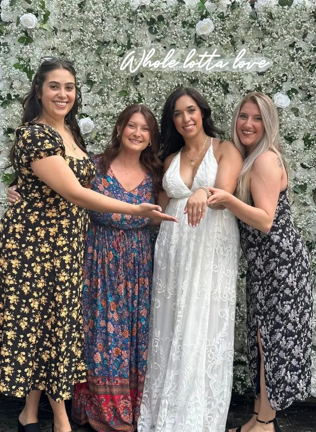 Friends celebrating with the bride at a floral backdrop